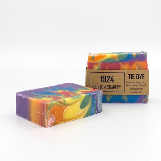 Two tie-dye soap bars with a '1924 Custom Soapery' box on a white background