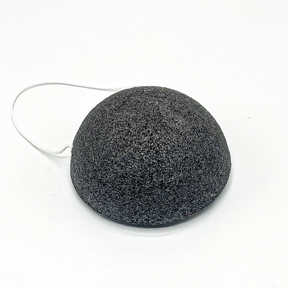 Black facial sponge with a string on a white background